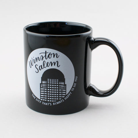 Black ceramic mug with hand lettering and illustration by Em Dash Paper Co. Winston-Salem: the city that's always happy to see you.